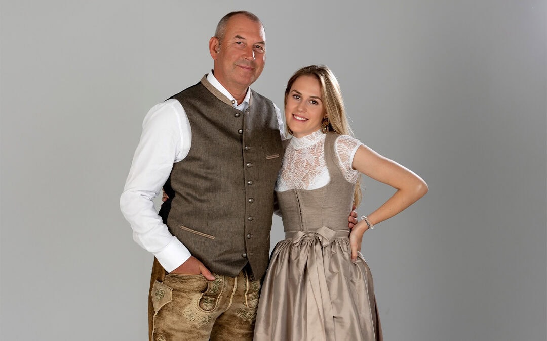 Portraitaufnahme von Familie Schwarz vom Hotel Alpina Alpendorf St. Johann in Pongau vor grauem Hintergrund