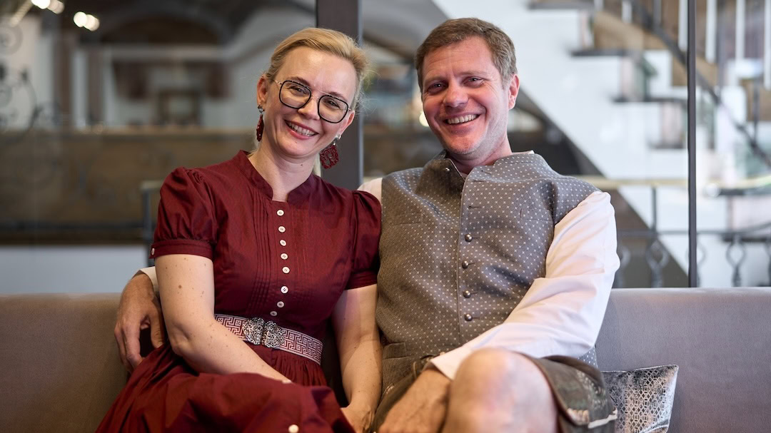Foto von Elisabeth und Mat Will vom Hotel Alpina Obertauern sitzend und lachend auf einer Couch