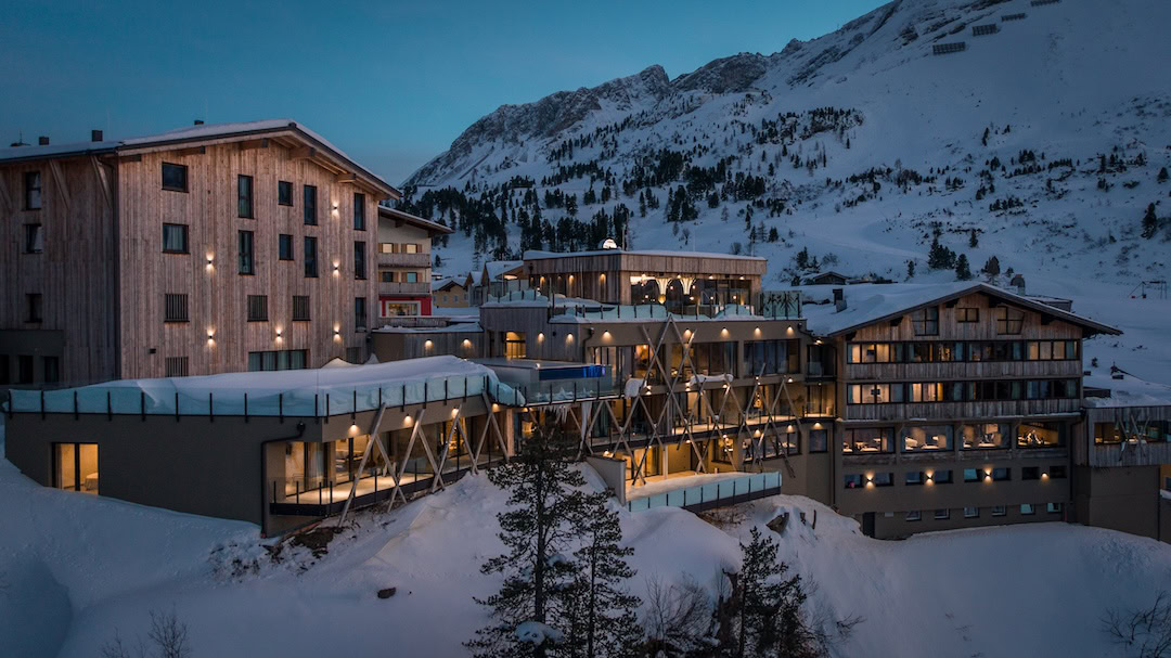 Außenansicht vom Hotel Kohlmayr in Obertauern in der Abenddämmerung in einer Winterlandschaft