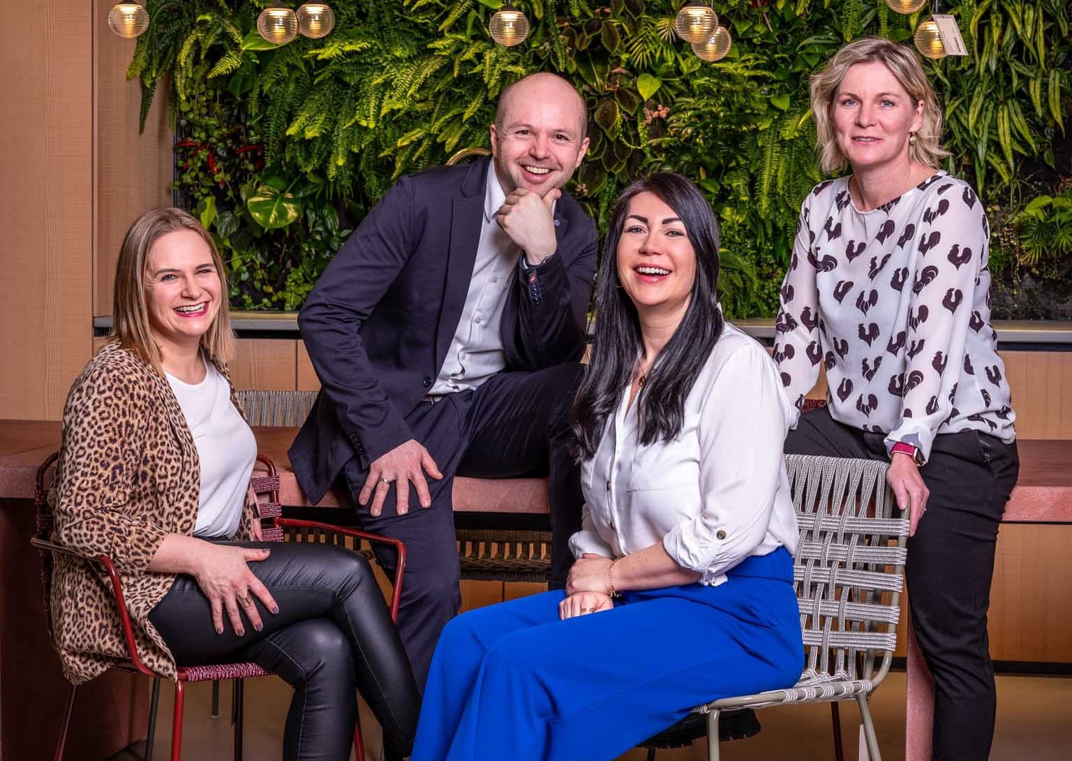 teamCoCo_Foto Ein Foto vom CoCo Cooking Concept Team lachend vor grünem Hintergrund