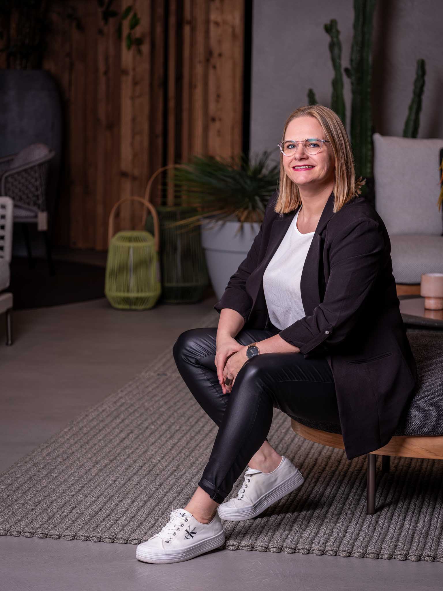 MitarbeiterinKarin_Portrait Ein Foto von Team CoCo Cooking Concept Mitarbeiterin Karin Sulzenbacher sitzend auf einem Sofa